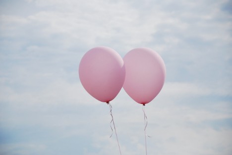 Ein glückliches Paar in einer Beziehung lässt nacher einer Beratung zwei luftballons in Frankfurt in Main in den Himmel steigen