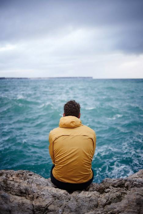 Ein Mann sitzt am Meer und denkt darüber nach ob eine Psychotherapie in Frankfurt vielleicht seine Ehe retten kann